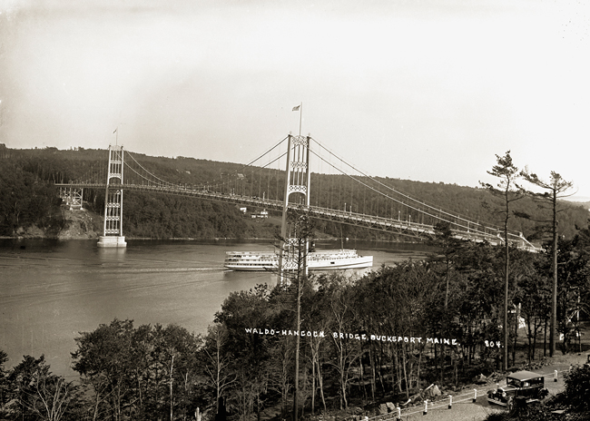 Steamer traveling under bridge.